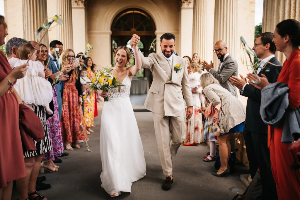 Hochzeitsfotograf Berlin Brandenburg - Hochzeitsreportagen ohne Kitsch. Kein Posing. Null Schnickschnack. Einfach nur ihr! Glückliches Hochzeitspaar läuft durch den Spalier ihrer Hochzeitsgäste nach der standesamtlichen Trauung im Belvedere Pfingstberg Potsdam